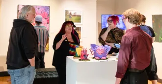 Visitors attending the opening night of the art gallery show QUEER: A Proud and Loud Art Show