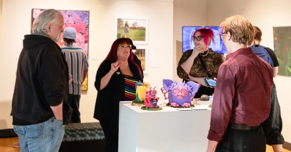 Visitors attending the opening night of the art gallery show QUEER: A Proud and Loud Art Show