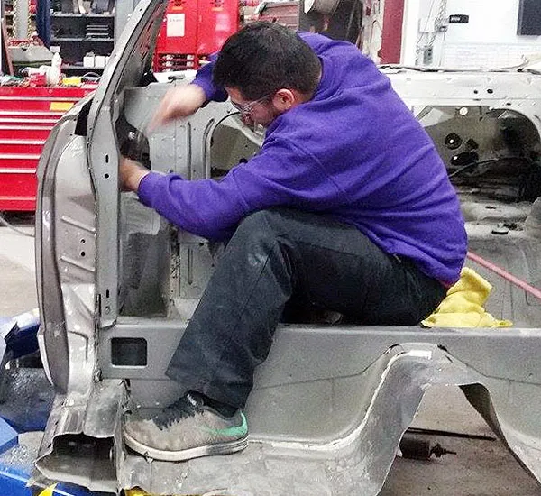 auto collision repair students working on a body panel section