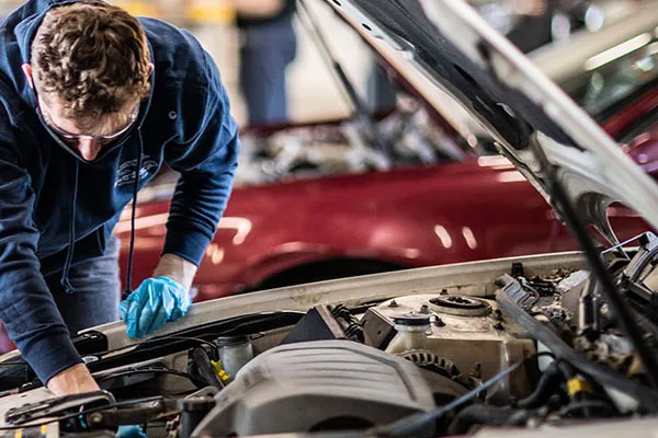 automotive technology student checking a car's radiator cooling fan