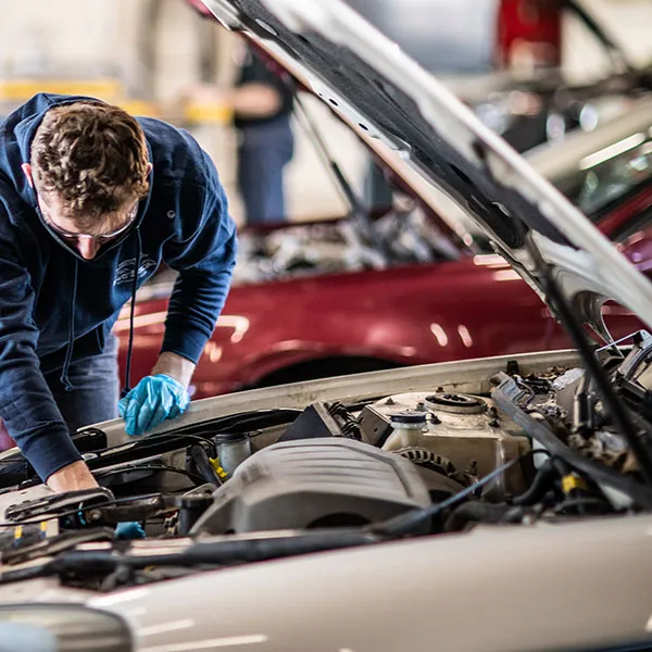 automotive technology student checking a car's radiator cooling fan