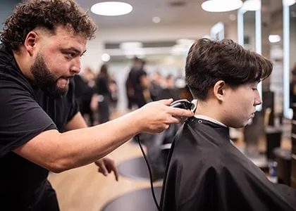 barber student trimming the back of a clients head