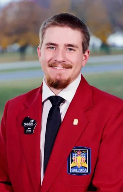 Ben Strupp, wearing a red blazer with the SkillsUSA badge on it, smiling at camera.