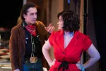 A man in western attire points at a woman in a red dress in a scene from Bus Stop