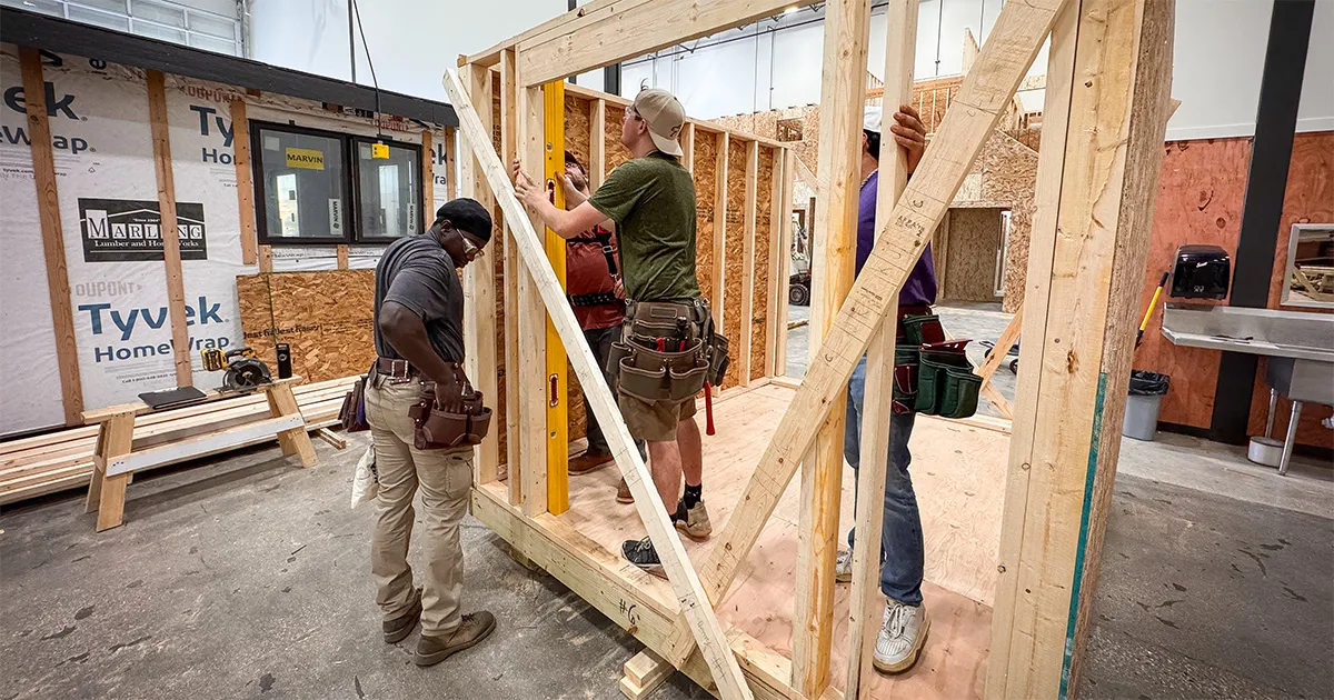 Construction students building a wall frame