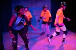 Four actors wearing helmets and knee pads in a scene from the Roller Derby Play