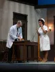 A nurse talks on a black corded phone while the doctor takes notes in a scene from the play Harvey
