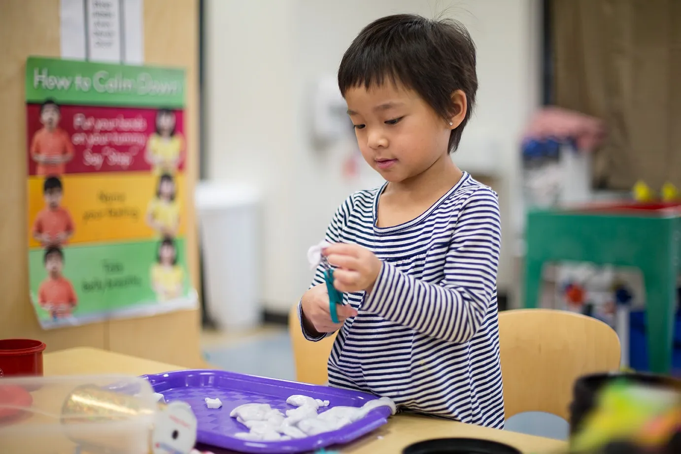 A child learns to use scissors at the ELC.