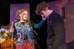 A young woman with a backpack and walking stick comforts a sad young man in a scene from Midwestern Goodbyes
