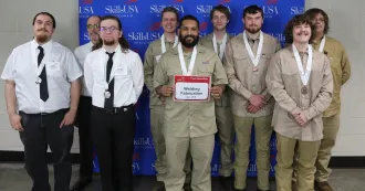 SkillsUSA student competitors, some in light brown shirts and others in white shirts and dark ties, posing with medals.