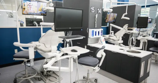 Dental patient chair with monitors and equipment.