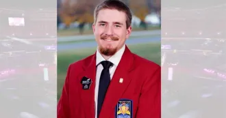 Ben Strupp wearing red blazer with SkillsUSA patch on it, smiling at camera.