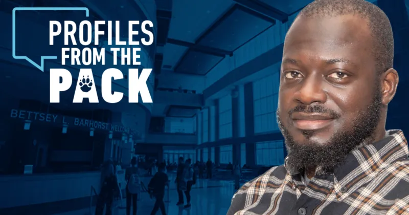 Student with brown skin, dark mustache and beard, wearing striped flannel shirt, smiling, with white Profiles from the Pack logo in background.