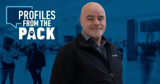 Photo of John Flannery with the Profiles from the Pack logo in the background.