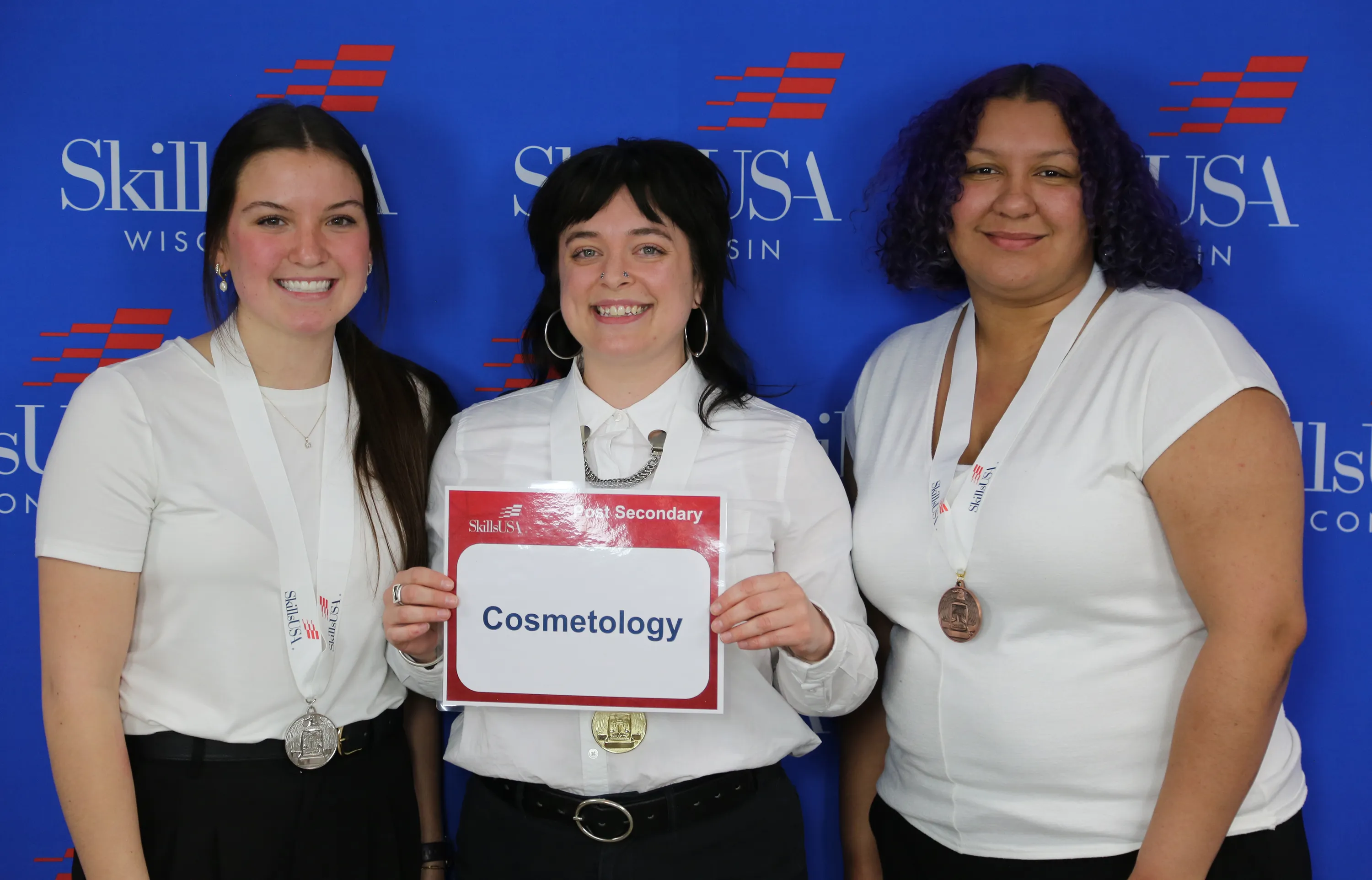 Three students, in white shirts and dark pants, holding certificate.